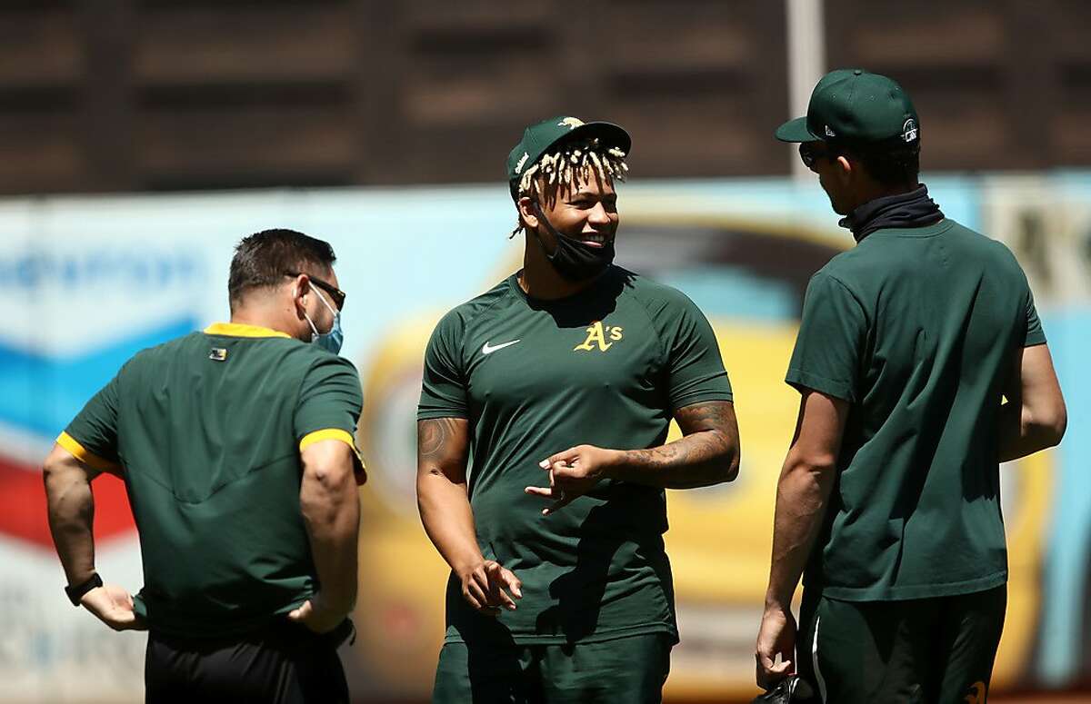 OAKLAND, CALIFORNIA - JULY 05: Frankie Montas #47 (center) of the Oakland Athletics speaks with teammates during summer workouts at RingCentral Coliseum on July 05, 2020 in Oakland, California. (Photo by Ezra Shaw/Getty Images)