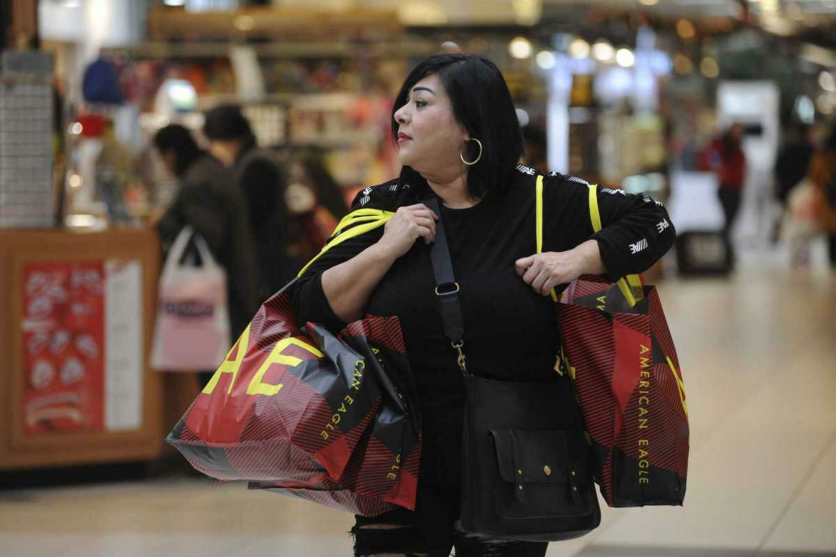 Anna Saldaña carries Christmas gift items purchased at American Eagle at South Park Mall on Black Friday, Nov. 29, 2019.