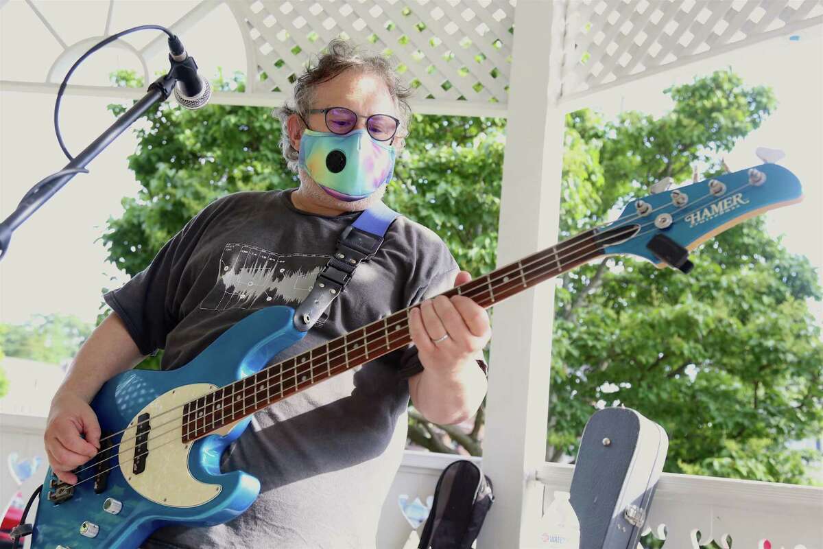 Bass player Allan Tepper of The Clams Casino prepares to perform at this season's first Sherman Green Summer Concert on Saturday, July 11, 2020, in Fairfield, Conn. Attendees were advised to keep their blankets and chairs at least 15 feet away from others, and when a 6-foot distance was deemed unavoidable, they were required to wear face coverings.