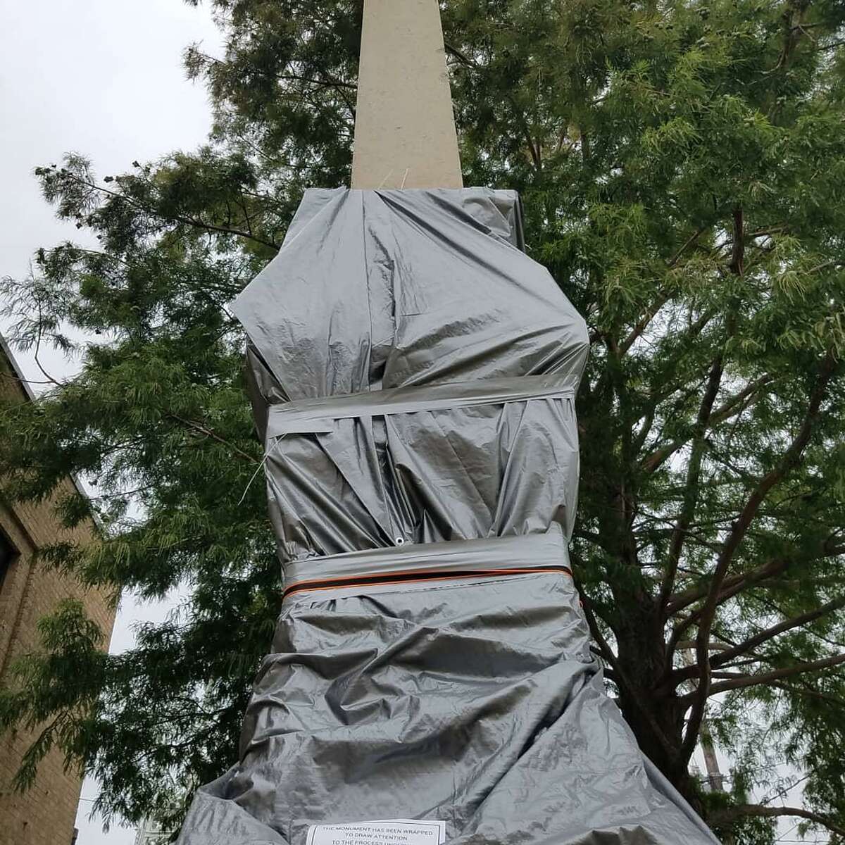 Activists pushing for the removal of the Jaybird-Woodpecker monument in Richmond, Texas have covered the statue in a tarp and erected a sign petitioning for its removal on July 12, 2020.