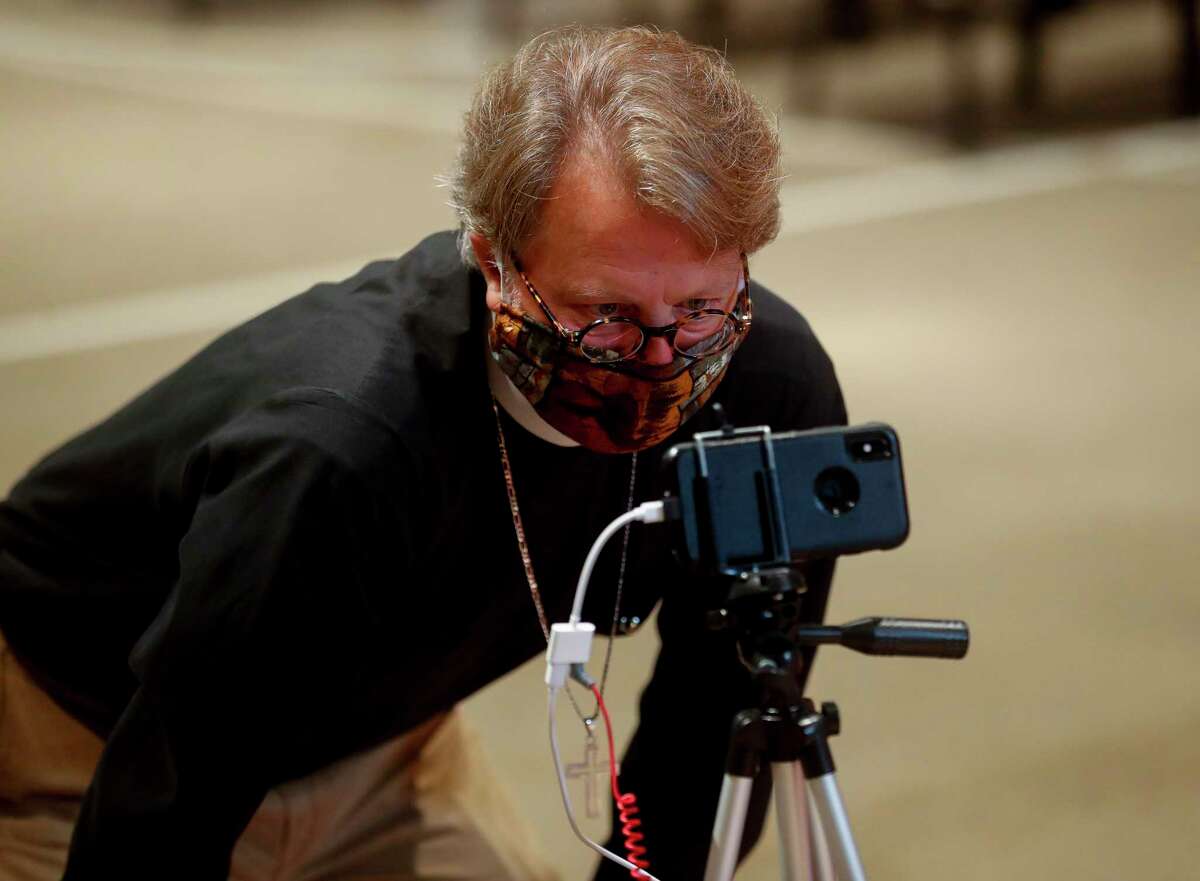 The Rev. Lance Ousley sets up a cellphone to test out live video feeds for future services at the new location for Church Emmanuel on Thursday, June 25, 2020, in Houston.