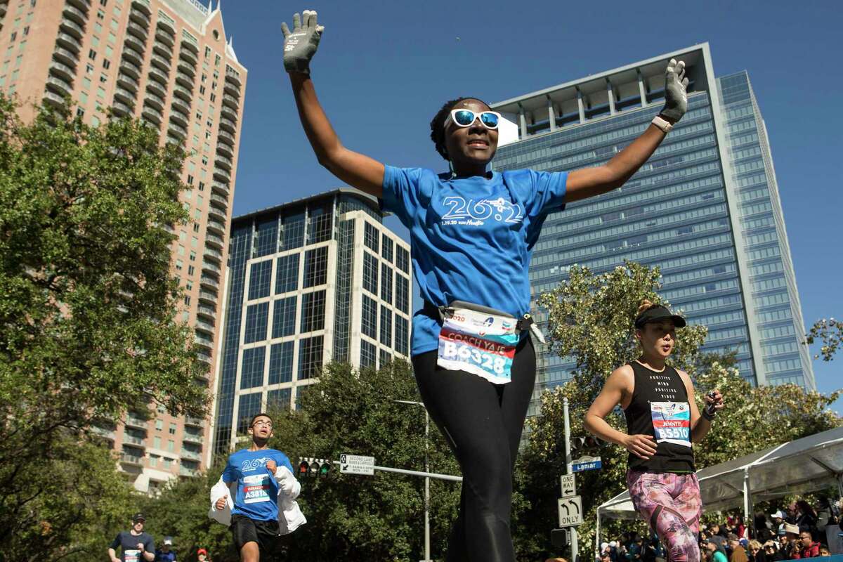 Yaje Ngala raises her arms as she kicks toward the finish line of the Chevron Houston Marathon Sunday, Jan. 19, 2020 in Houston.