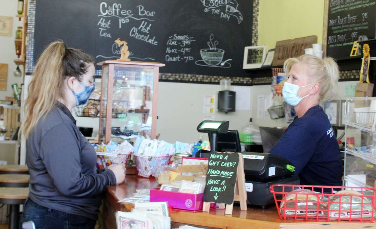 A customer wearing a face mask orders a meal to-go Monday at the Yellow Window in downtown Big Rapids. Gov. Gretchen Whitmer, last week, mandated that Michigan businesses open to the public deny service or entry to customers who refuse to wear one starting Monday.