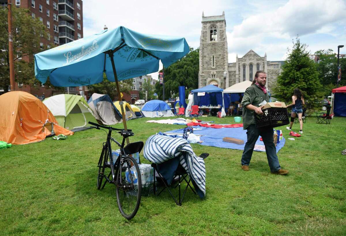 Bridgeport's Erik Kuranko carries supplies through the Latham Abolition Camp at Latham Park in Stamford, Conn. Monday, July 13, 2020. A group of protestors has been camped out at Latham Park since the weekend protesting the death of Steven Barrier, who died in police custody in October of 2019, and demanding reform from the local police department.