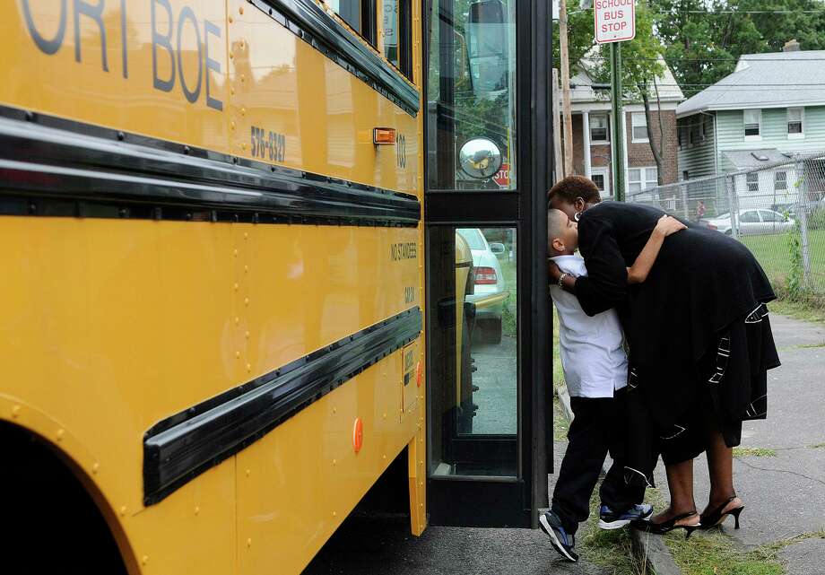 Hall School principal Veronica Thomas and fourth-grader Joshua Martinez greet each other as he steps off the school bus on the first day of school in Bridgeport, CT on Wednesday August 25, 2010. Photo: Shelley Cryan / ST / Shelley Cryan Freelance