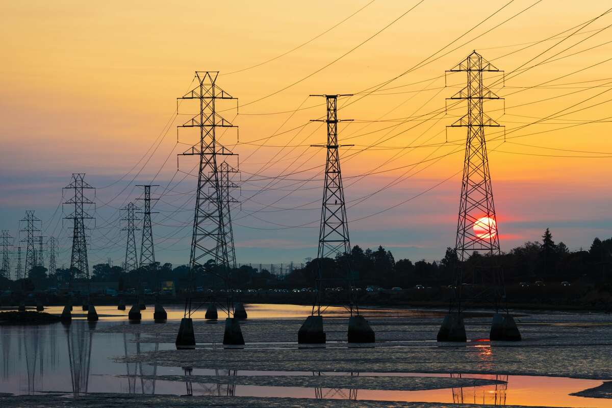 Power transmission tower is silhouetted by the rising sun in Burlingame, Calif., on Oct. 26, 2019.