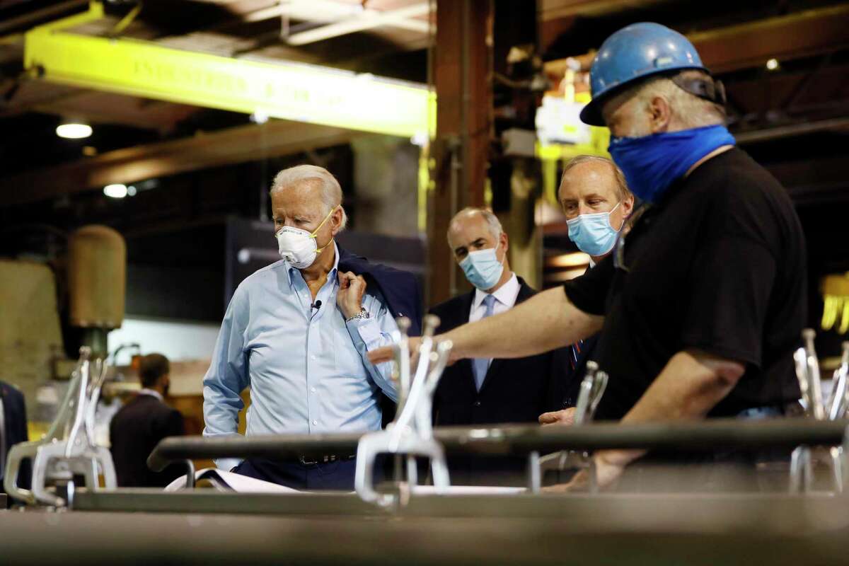 Democratic presidential candidate, former Vice President Joe Biden, from left, Sen. Bob Casey, D-Pa., and McGregor Industries owner Bob McGregor listen to First Class Fitter Michael Phillips during a tour of the metal fabricating facility in Dunmore, Pa. Biden is pledging to define his presidency by a sweeping economic agenda beyond anything Americans have seen since the Great Depression and the industrial mobilization for World War II.