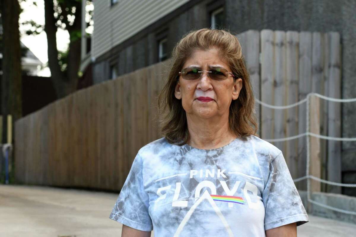 Carol Eto stands near a fence separating her property from her neighbor, Yugeshwar Gaindarpersaud, which she says has caused friction between the two on Tuesday, July 14, 2020, in Schenectady, N.Y. Gaindarpersaud was recently involved in an altercation with a city cop, hastening local police reforms. (Will Waldron/Times Union)