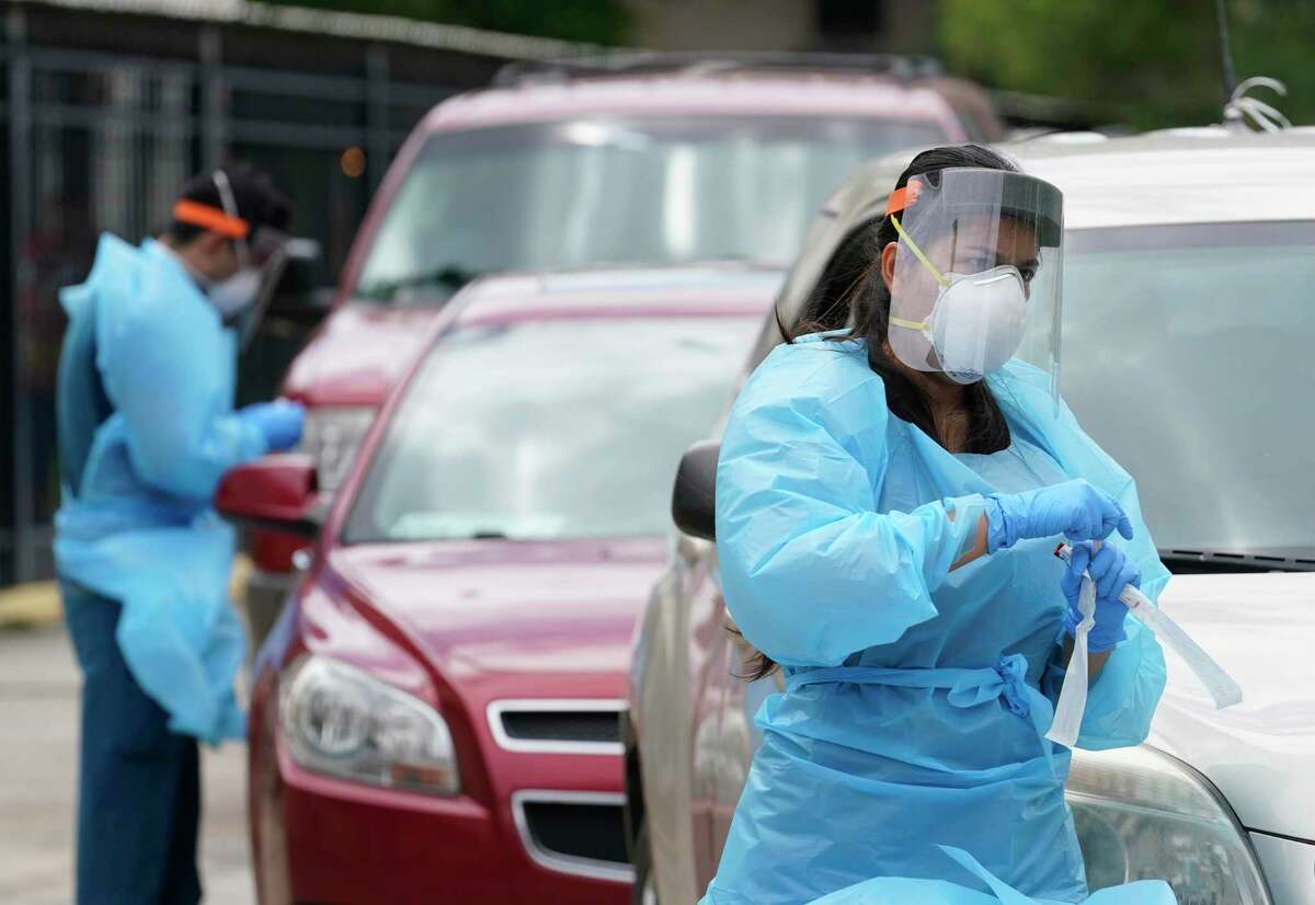 Healthcare personnel work at free COVID-19 testing site conducted by United Memorial Medical Center at the Consulate General Of Mexico, 4506 Caroline St., Sunday, June 28, 2020, in Houston.