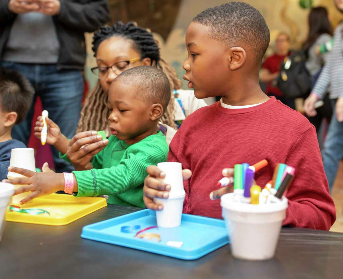 Elijah Mentore watches his brother, Emmanuel Mentore, build a noisemaker at the 9th annual High Noon Countdown event at the Woodlands Children's Museum, Tuesday, Dec. 31, 2019. The museum hosts its annual High Noon Countdown starting at 9:30 a.m. Dec. 31. 