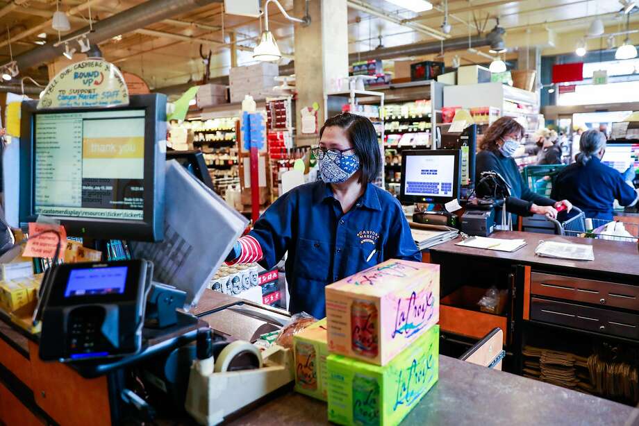 Essential worker Noreen Dosayla checks out a customer at Canyon Market in San Francisco, California on Monday, July 13, 2020. Photo: Gabrielle Lurie / The Chronicle