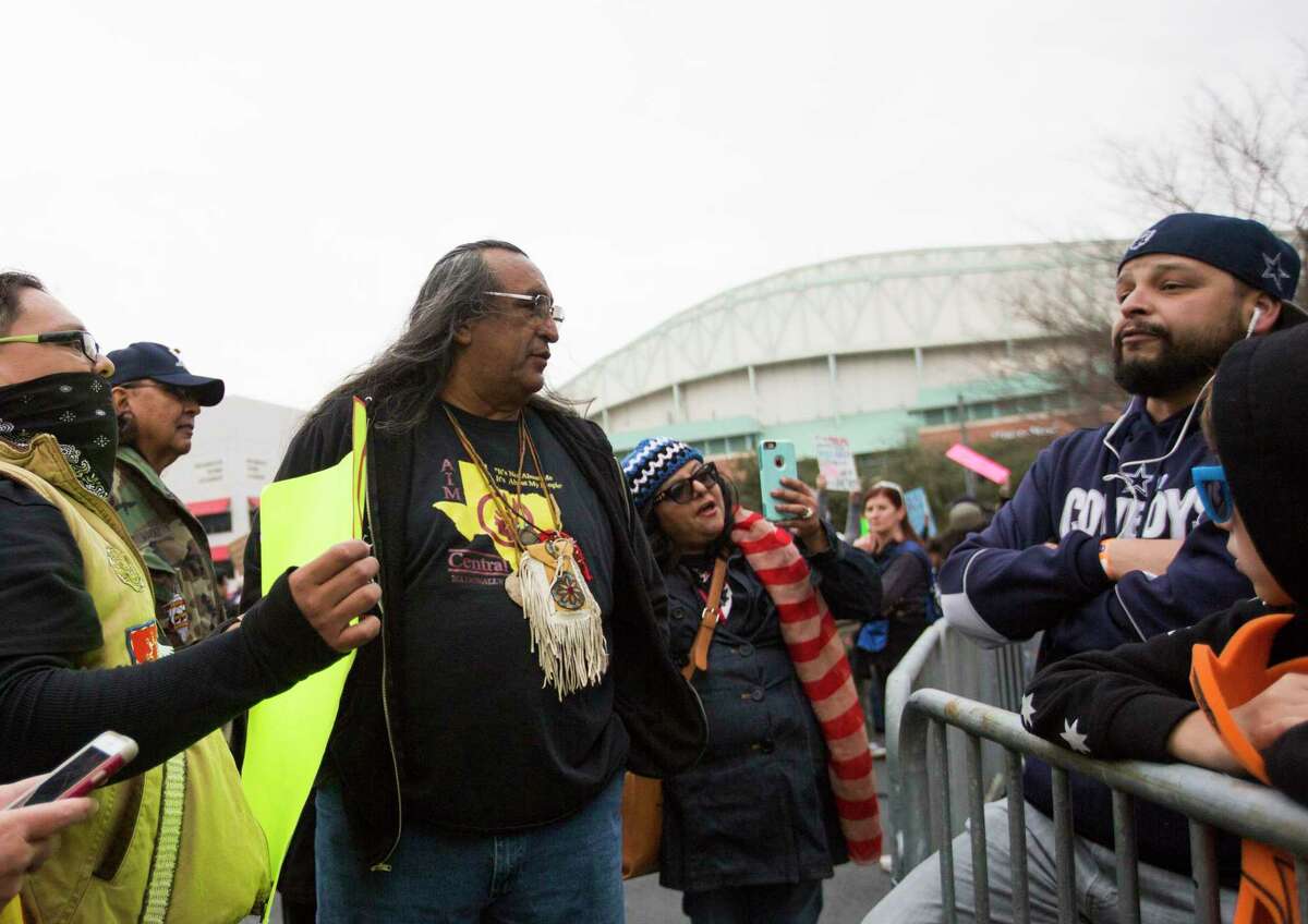 Juan Manias, center, a member of the Carrizo Comecrudo Tribe of Texas tries to explain his position on the importance to protect natural resources and Native American territory to a skeptic near the George R. Brown Convention Center where the Super Bowl LIVE events took place, Saturday, Feb. 4, 2017, in Houston.