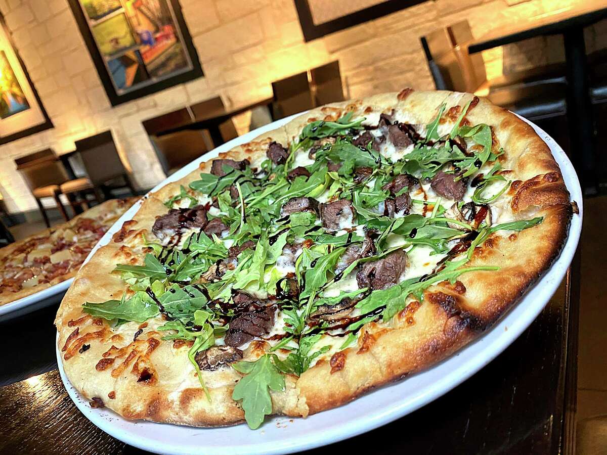 The S&M pizza incorporates sirloin steak, mushrooms, white sauce, arugula and balsamic reduction at Embers Wood Fire Kitchen & Tap in Stone Oak.