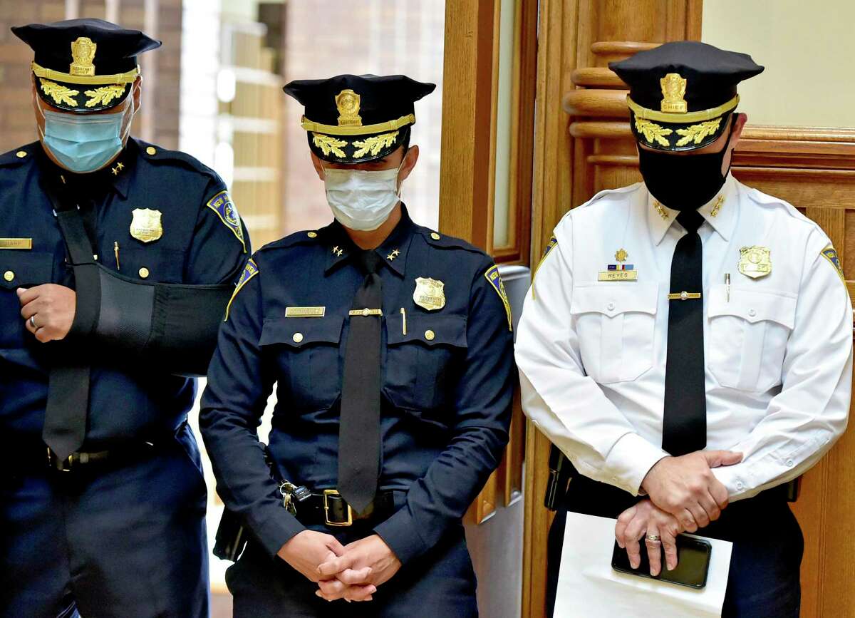 New Haven, Connecticut - Wednesday, July 15, 2020: New Haven Police assistant chiefs Herbert Sharp, left, and Rene Dominguez, center and Police Chief Otoniel Reyes bow their heads in prayer at the start of a press conference Wednesday at New Haven City Hall hosted by Reyes and New Haven Mayor Justin Elicker and attended by community leaders to provide comment on the City’s plan to address the growing violent crime in the Elm City.