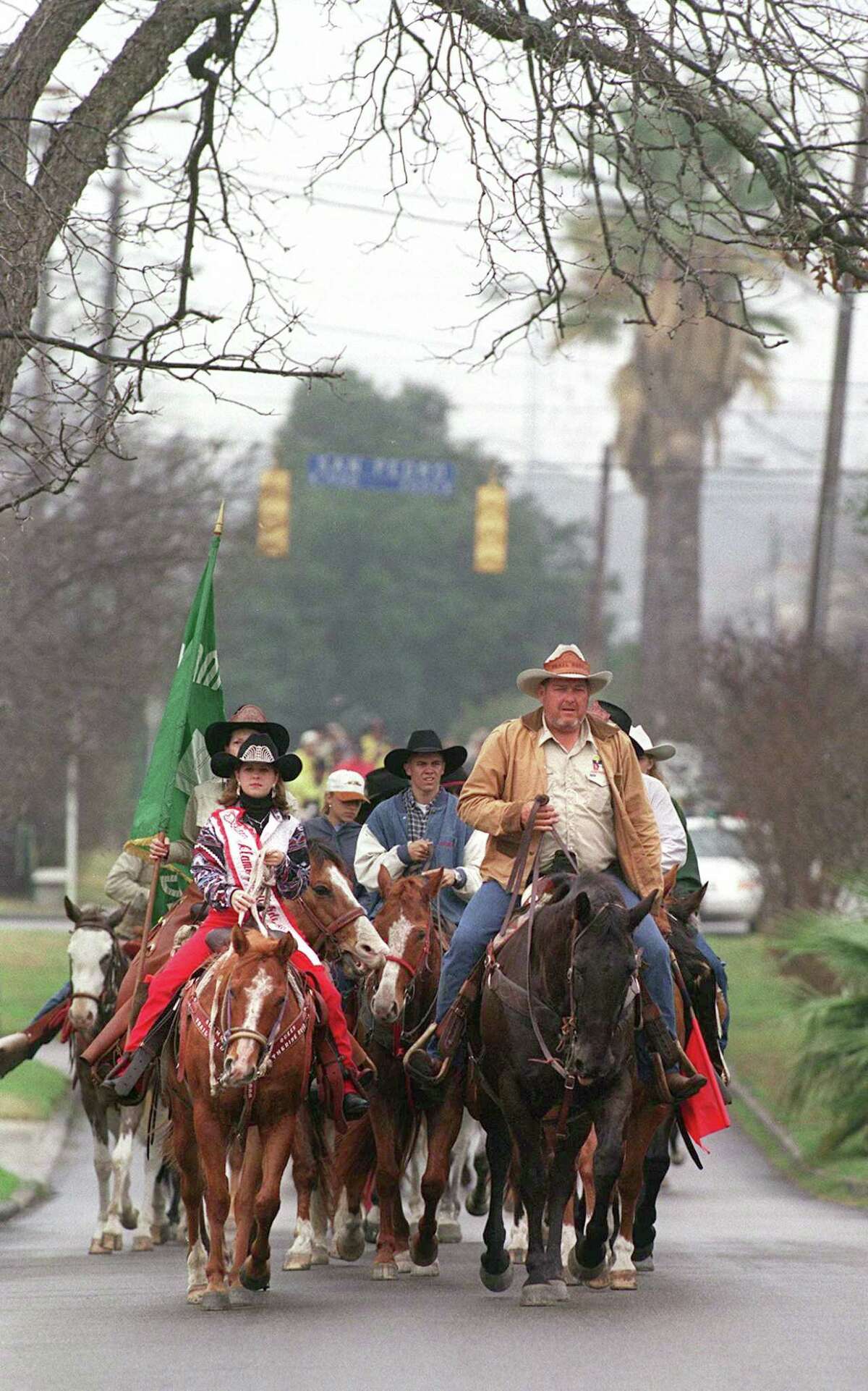 FOR DAIL Y METRO-- Trail boss Kyle Coleman (right) and trai ride queen Katherine Ruiz (left) lead the Alamo Trail Ride, on the road for the last seven days, up Woodlawn Ave. Friday morning on the last leg of their trip, arriving for the start of the stock show and rodeo which starts Saturday. Rick Hunter/Staff