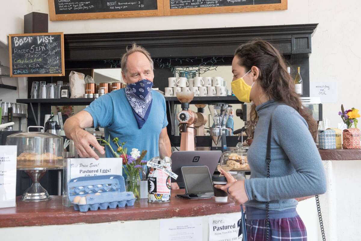 Mercury Cafe owner Nick Parker shows off pasture-raised eggs the cafe now sells to client Lindsay Rawitscher. Coffee is one of the companies that received a PPP loan in the Hayes Valley.