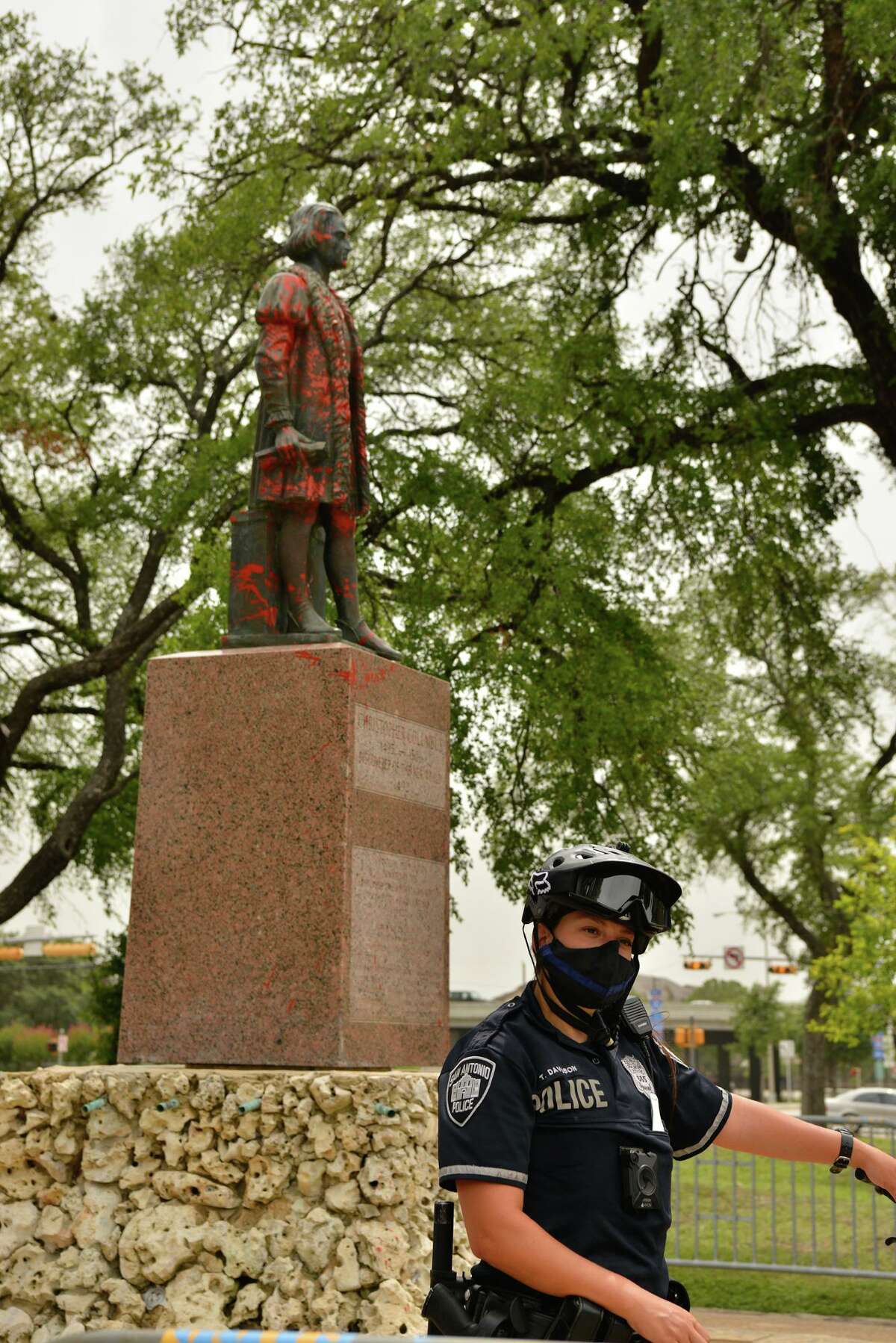Police stand guard around the Christopher Columbus statue after a demonstration in the park Saturday afternoon.