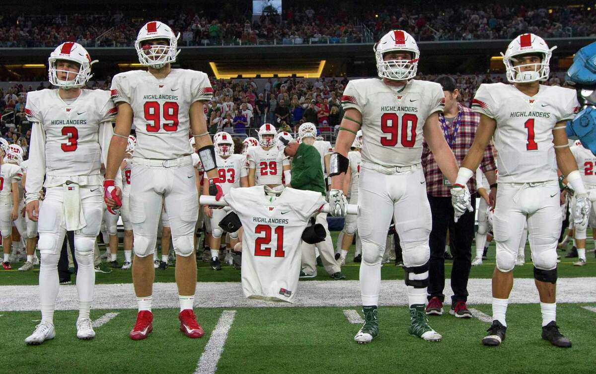 The Woodlands football players Michael Purcell, left, and Zachary Loane carry the jersey of linebacker Grant Milton, who was named an honorary captain before a UIL Class 6A Division I state final against Lake Travis at AT&T Stadium Saturday, Dec. 17, 2016, in Arlington. Grant was injured during the team?•s state playoff game against Austin Bowie on Nov. 26 at McLane Stadium on the campus of Baylor University. After brain surgery and 17 days in a Waco hospital, Grant was transferred to a medical facility in The Woodlands Nov. 13