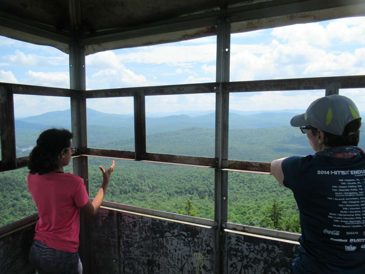 Outdoor writer Gillian Scott and her daughter in the cab of the fire tower on Stillwater Mountain in Old Forge several weeks ago. (Herb Terns / Times Union)