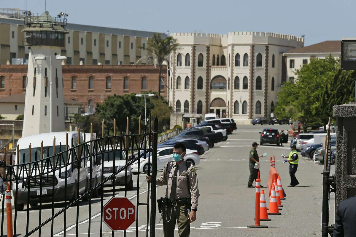 FILE - In this July 9, 2020, file photo, a correctional officer closes the main gate at San Quentin State Prison in San Quentin, Calif. There has been a major drop in the number of people behind bars in the U.S. due to the coronavirus, Between March and June, more than 100,000 people were released from state and federal prisons, a decrease of 8%, according to a nationwide analysis by The Marshall Project and The Associated Press. (AP Photo/Eric Risberg, File)