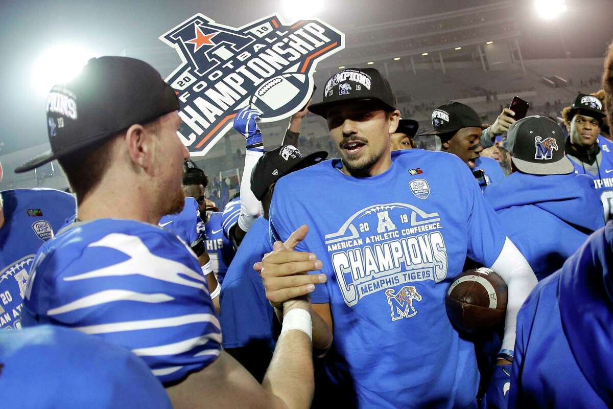 FILE - In this Dec. 7, 2019, file photo, Memphis quarterback Brady White, center, celebrates after his team defeated Cincinnati in an NCAA college football game for the American Athletic Conference championship, in Memphis, Tenn. The American Athletic Conference will require all its schools to test football players for COVID-19 at least 72 hours before competition. The announcement Thursday, July 16, 2020, by the American comes ahead of the expected release of recommendations for testing before games from the NCAA. (AP Photo/Mark Humphrey, File)