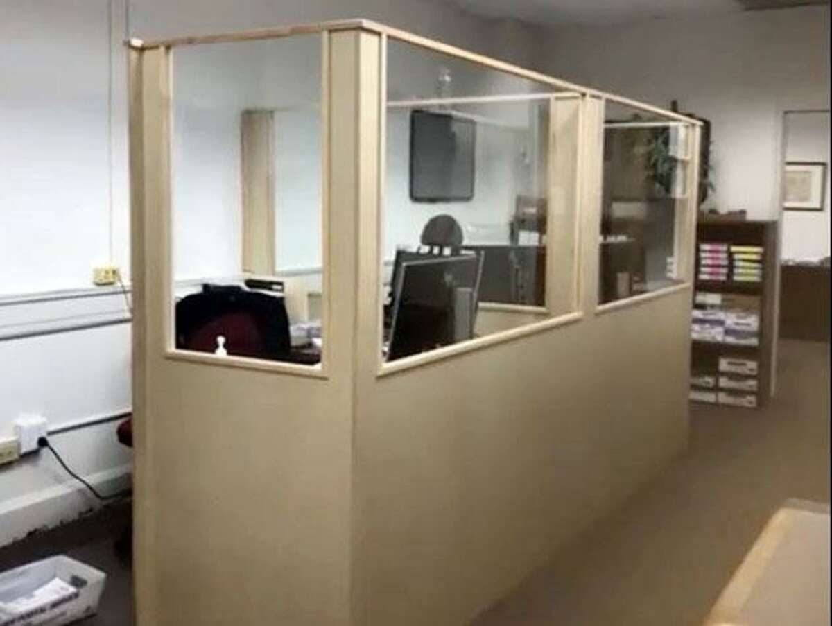A new composite wood base and glass windows surround a work station in Wilton's tax office as part of recent coronavirus protection renovations.