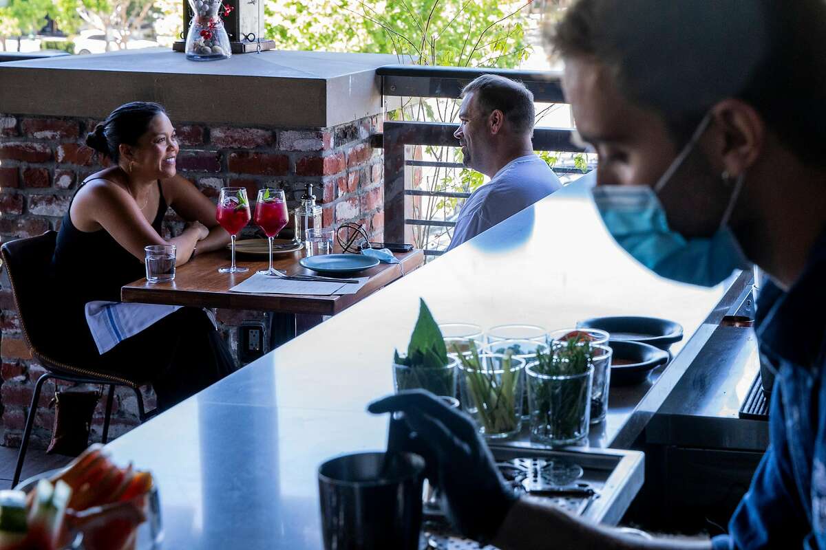 Customers dine indoors at Teleferic Barcelona in Walnut Creek, Calif.  Contra Costa and Santa Cruz  counties were moved to the red tier on Tuesday, which mostly requires reduced capacity in indoor spaces.