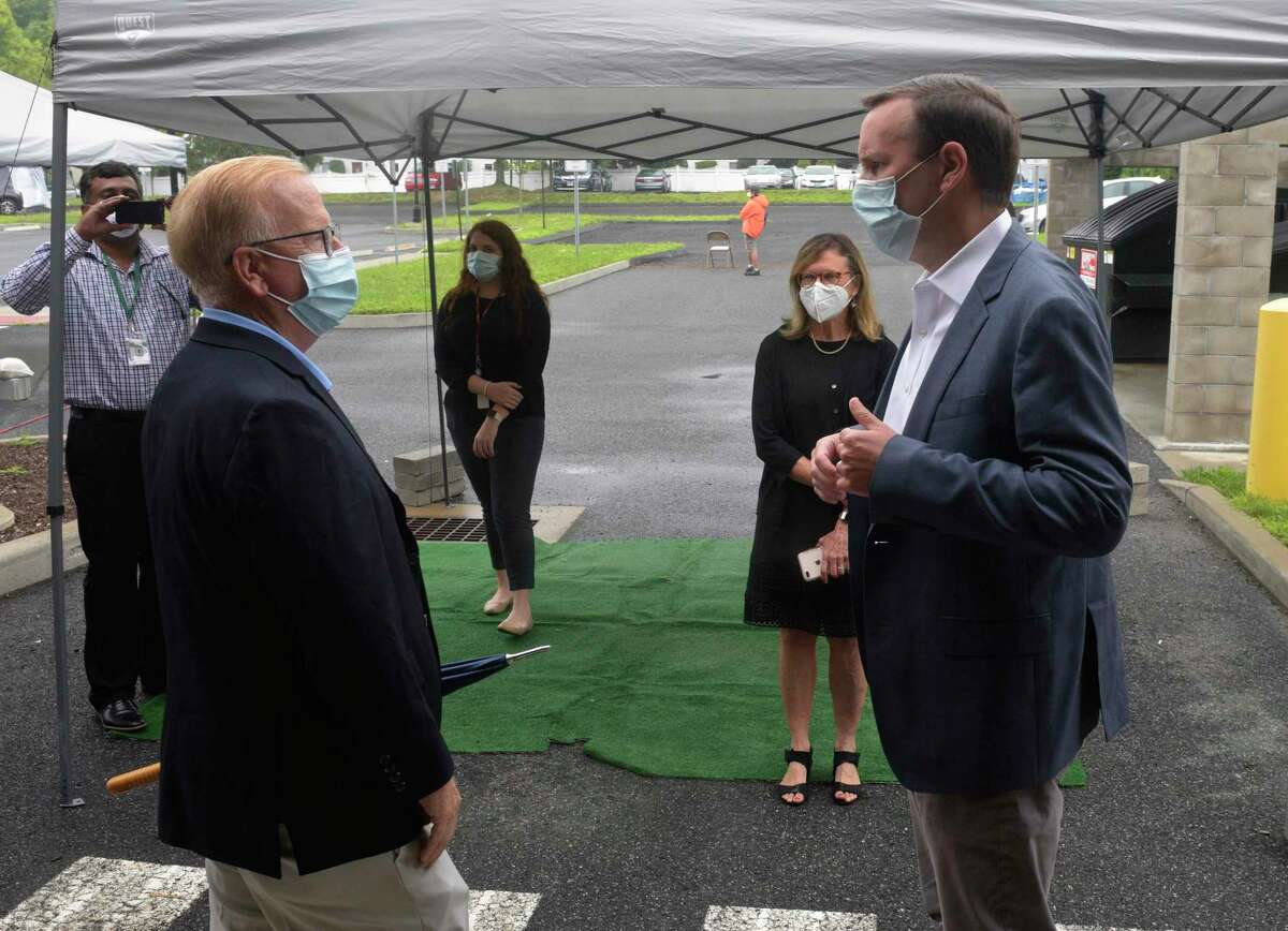 U.S. Sen. Chris Murphy talks with Mayor Mark Boughton as he visits the community health center Connecticut Institute for Communities, to promote increased COVID-19 testing. Friday, July 17, 2020, in Danbury, Conn. Conn State Sen Julie Kushner looks on.