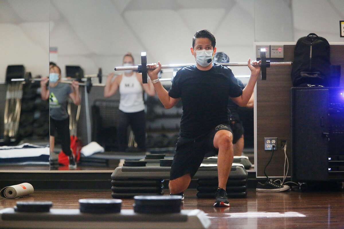 Joe Solis (right), group fitness instructor, wears a mask as he teaches a Body Pump class at the 24 Hour Fitness/Redwood City Super Sport to �customers wearing masks on Friday, July 17, 2020 in Redwood City, Calif.