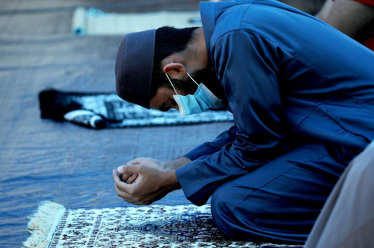 At Abdullah Anwar, nephew of Imam Tahir Anwar, prays as his uncle leads congregants in prayer at SBIA Mosque, Masjid al-Mustafa on Friday, July 17, 2020, in San Jose, Calif. "So, as you know, Friday is our day of congregation and we all congregate in the afternoon, about 5-700 people here at the mosque. We received restrictions that we were not allowed to congregate. So, as of March, we haven't had any congregations," Imam Tahir Anwar said. "And a few weeks ago when we were told we can congregate 25 people outside - we've been doing that the last few weeks. But, today was a very special day for us and the reason behind that was today was the first time we actually had 60 people that were able to congregate for prayers. Today was the largest number we have had in four months. And by the way, the number that we had today is a fraction of our normal congregation. So, while it's a very small number relatively speaking, we're actually really excited because it's the largest we've had in months."