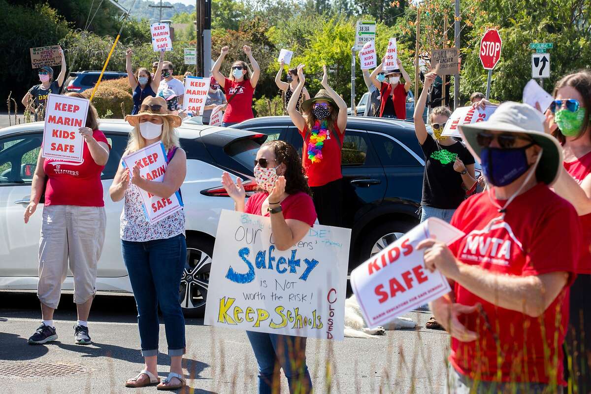 People rally outside the Marin County Office of Education on Thursday, July 16, 2020, in San Rafael, Calif. Teachers and their supporters across California are protesting school district plans for in-person learning, amid the coronavirus pandemic.