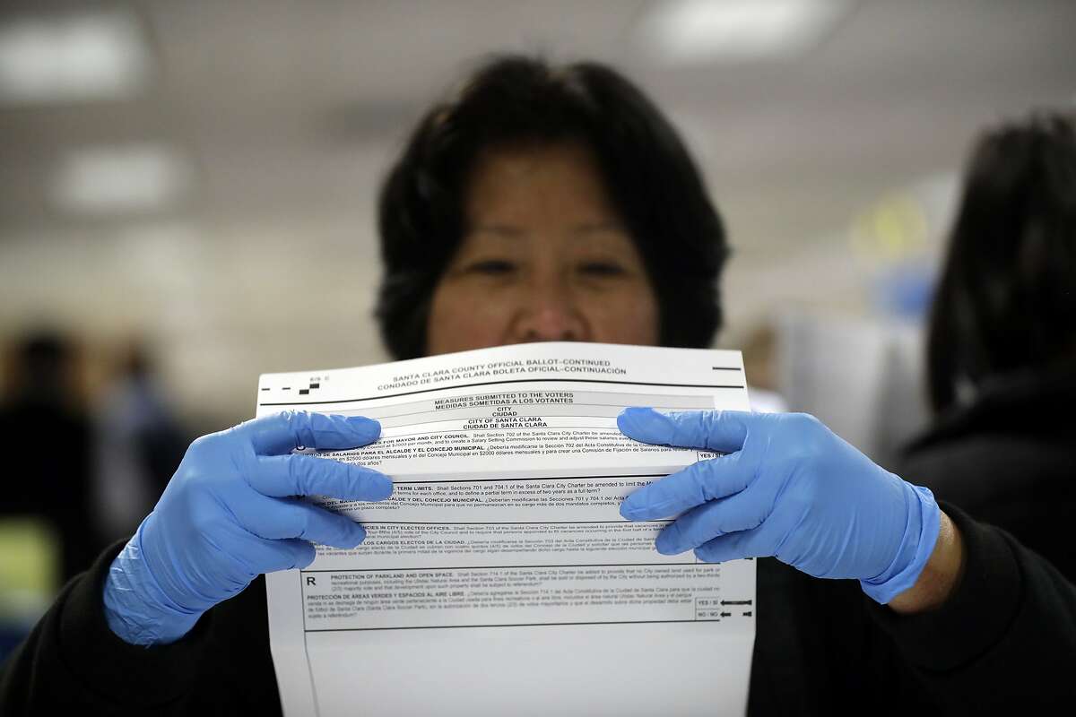 FILE - In this Nov. 4, 2016, file photo, a mail-in ballot is examined at the Santa Clara County Registrar of Voters in San Jose, Calif. The California Assembly on Thursday, June 18, 2020, sent Gov. Gavin Newsom a bill to require county election officials to mail a ballot to every registered voter in the state, which would cement into law the Democratic governor's earlier order to mail out ballots statewide in response to the coronavirus outbreak. Newsom, citing health risks, announced in early May that the state will send every voter a mail-in ballot for the November contest, but that order has been challenged in court. (AP Photo/Marcio Jose Sanchez, File)