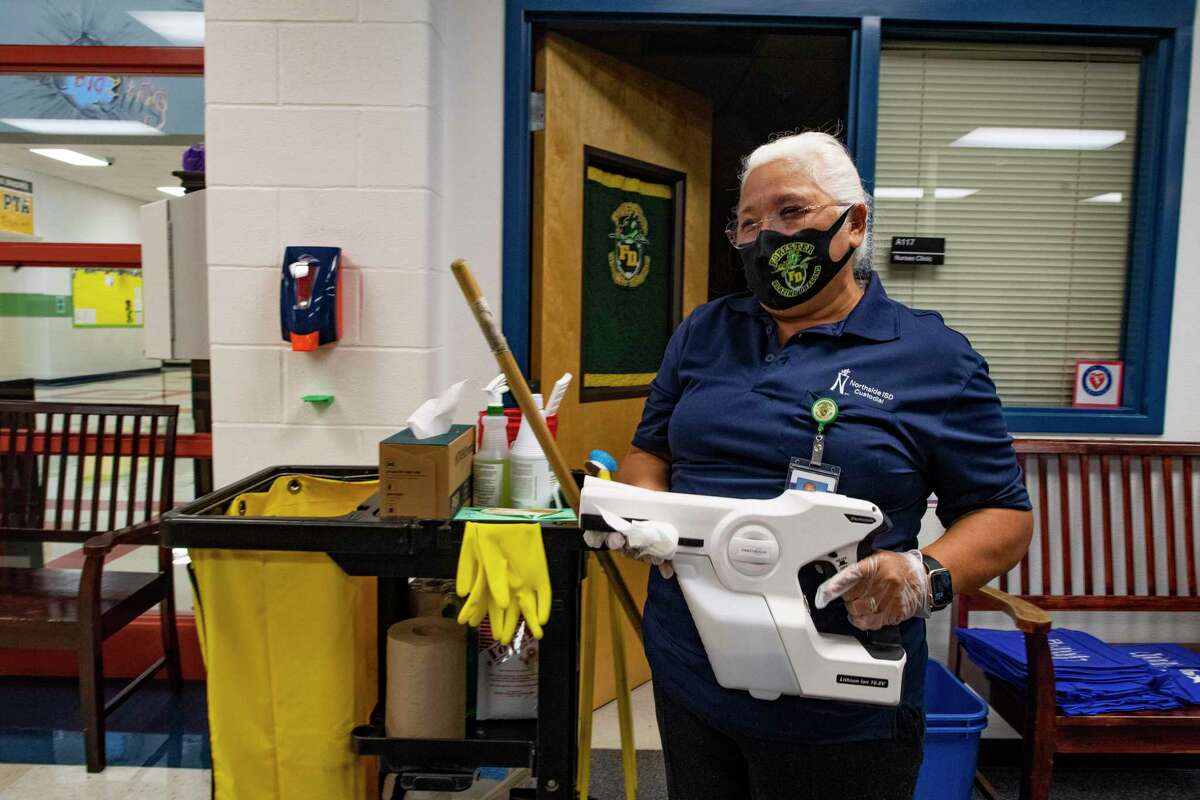Maria Reyes, head custodian at the Northside ISD's Forester Elementary School, works with a sanitizing spray gun on Friday. Reyes has reported to work almost every day since the beginning of the coronavirus pandemic because she wants to keep the school safe.