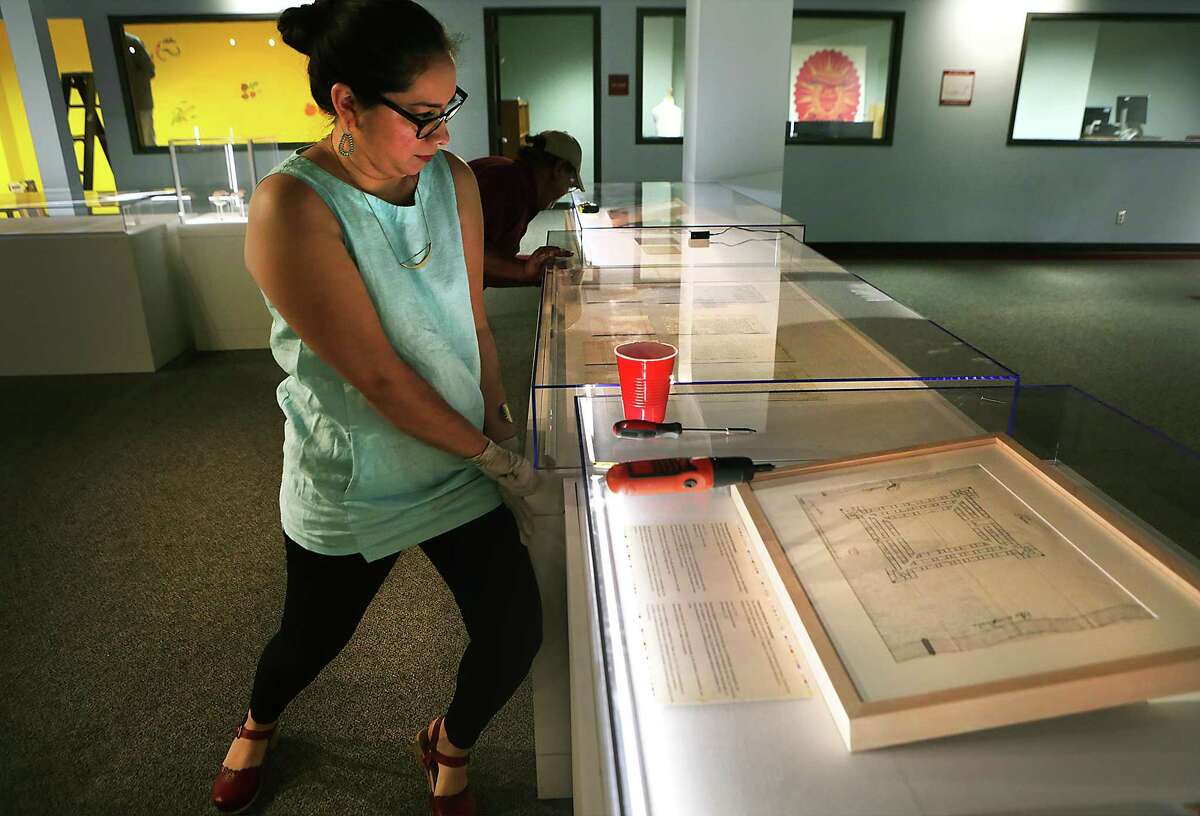 Dr. Sarah Zenaida Gould, left, Lead Curatorial Researcher with Institute of Texan Cultures, and Domingo Yruegas set up the exhibit Nuestra Historia-Our History: Spain in Bexar County, with Spanish colonial documents from Spain, on Monday, April 25, 2016.