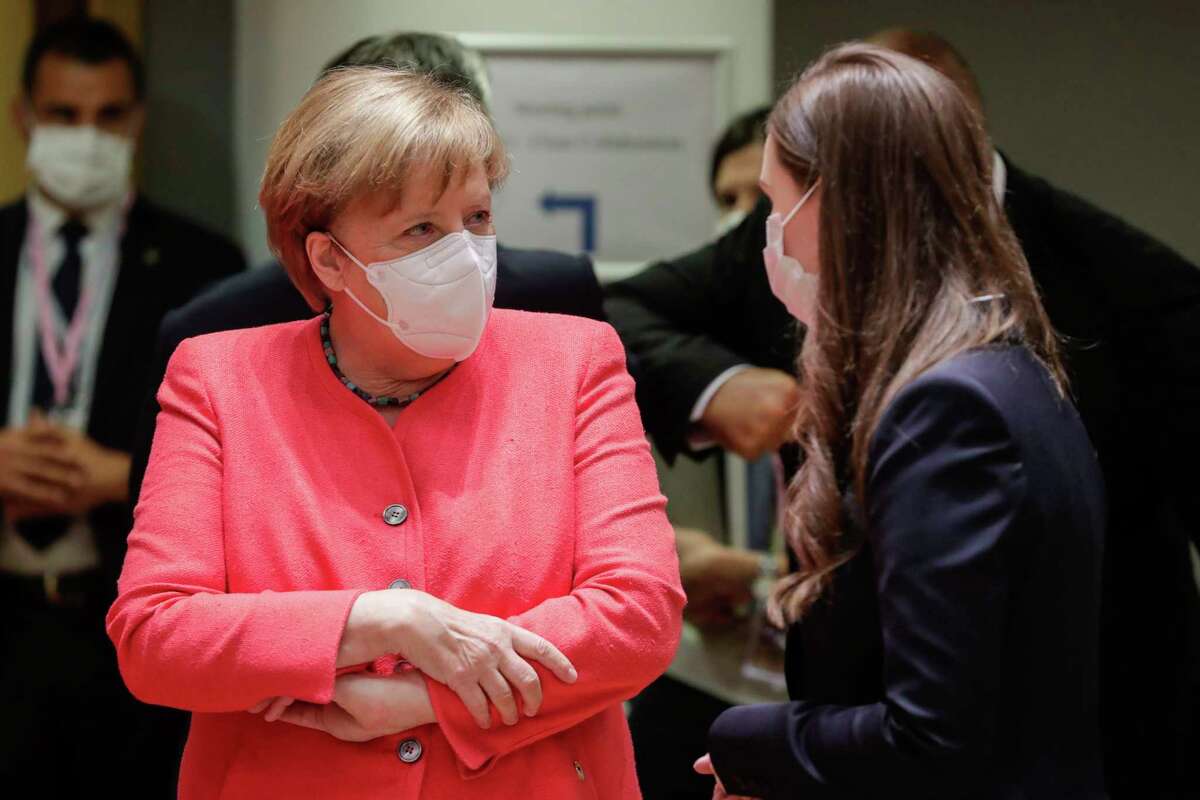 German Chancellor Angela Merkel, left, speaks with Finland's Prime Minister Sanna Marin during a round table meeting at an EU summit in Brussels, Friday, July 17, 2020. Leaders from 27 European Union nations meet face-to-face on Friday for the first time since February, despite the dangers of the coronavirus pandemic, to assess an overall budget and recovery package spread over seven years estimated at some 1.75 trillion to 1.85 trillion euros. (Stephanie Lecocq, Pool Photo via AP)