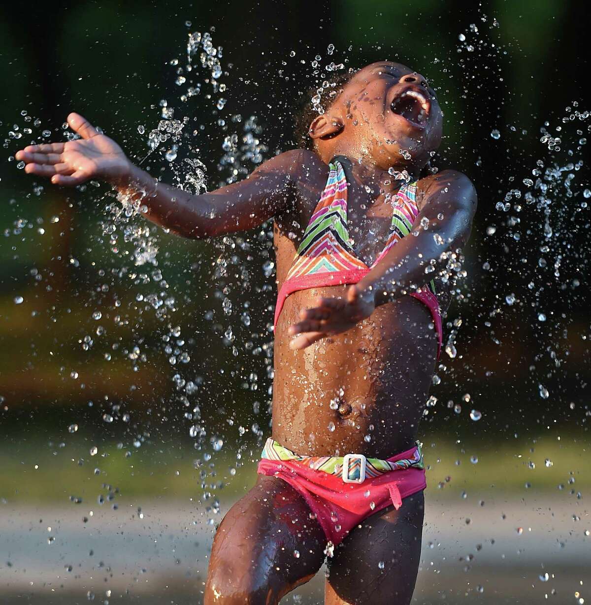New Haven resident Jazmyne Pearson, Jr., 4, cools off at the splash pad at Scantlebury Park, Wednesday, July 6, 2016, in New Haven. (Catherine Avalone/New Haven Register)