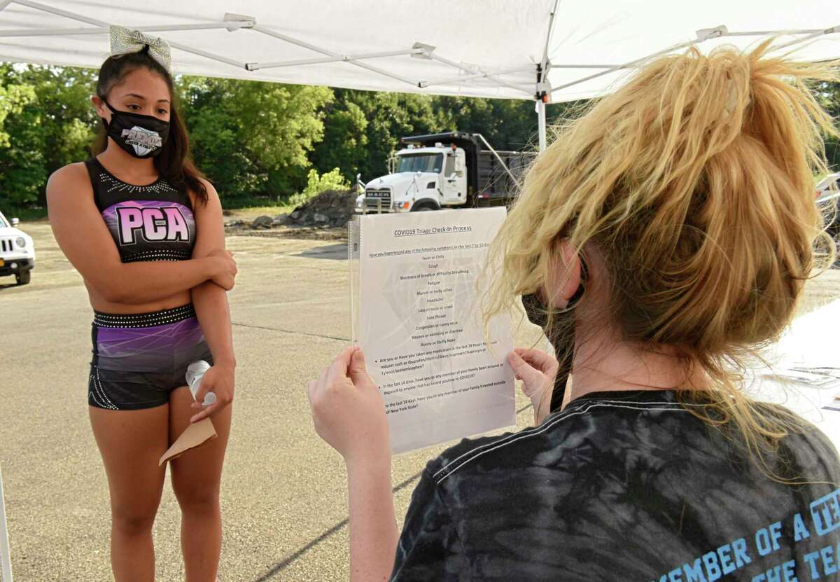 Miranda Diaz, 14, of Albany checks in and answers questions for COVID-19 screening before going in the building during tryouts for the group's hip-hop competitive team at Premier Cheer Academy on Friday, July 17, 2020 in Albany, N.Y. (Lori Van Buren/Times Union7