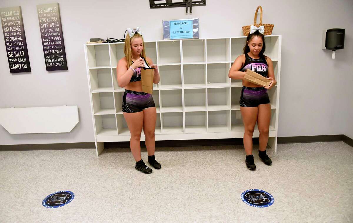 Alex Joslyn, 15, of Latham, left, and Miranda Diaz, 14, of Albany, put their face masks in paper bags as they enter the gym area during tryouts for the group's hip-hop competitive team at Premier Cheer Academy on Friday, July 17, 2020 in Albany, N.Y. (Lori Van Buren/Times Union7