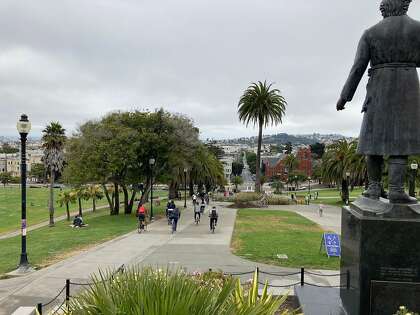 About a dozen cyclists race down the Cumberland slope, from the Miguel Hidalgo statue in Dolores Park to Dolores Street, on Sunday in San Francisco, near the site where a skateboarder and bicyclist collided Friday evening.