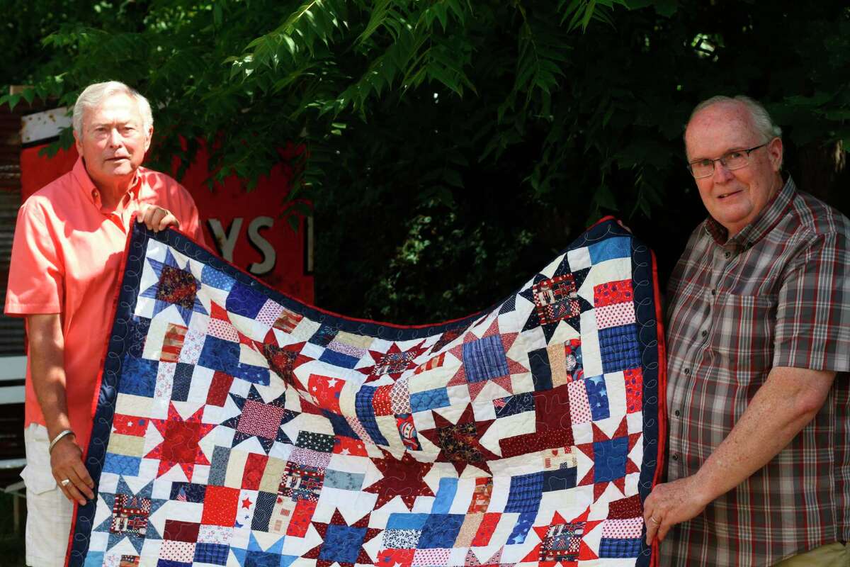 John Wemlinger (left) receives a Quilt of Valor from Bert Murphy (right) during a small ceremony at the Yellow Dog Cafe in Onekama on Friday. (Kyle Kotecki/News Advocate)