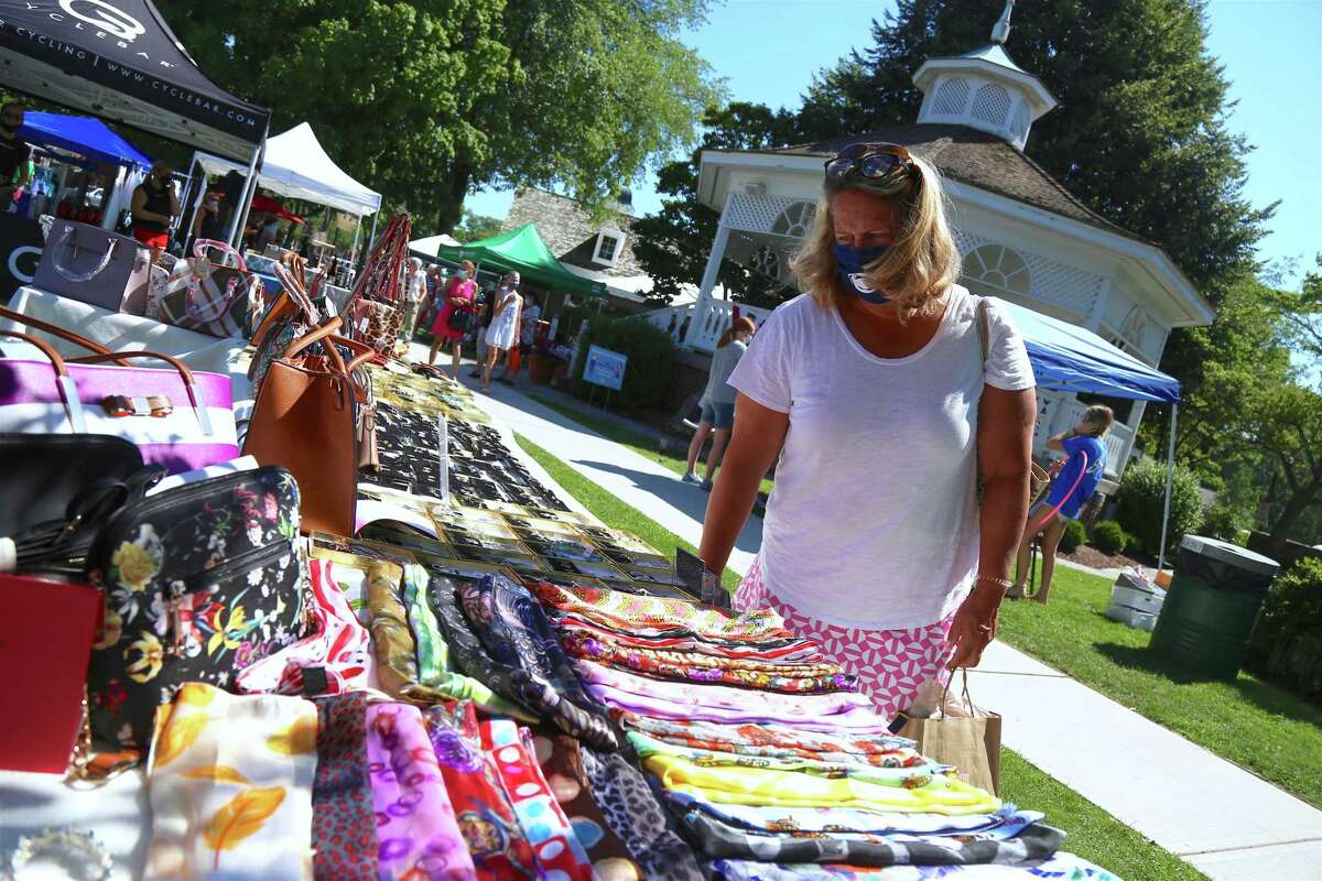 Christine Schwartzstein of Fairfield looks over the offerings of Fairfield-based Champagne Taste at the annual Sidewalk Sale & Street Fair on Saturday, July 18, 2020, in Fairfield, Conn.