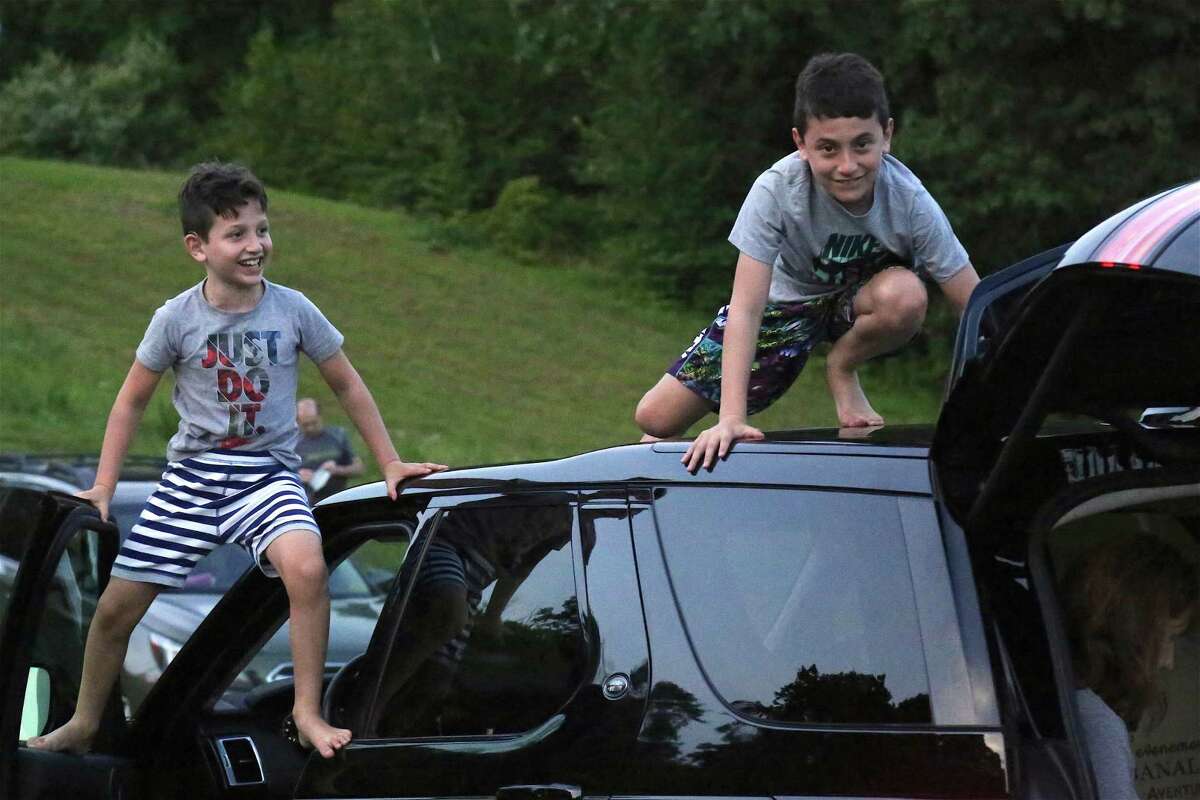 Benjamin Zev, 7, left, of Weston, and his brother Eli, 10, do some climbing at the Lachat Town Farm pop-up drive-in movie screening of "Caddyshack" on Sunday, July 19, 2020, in Weston, Conn. "This place is amazing," said Nashawaty, a Westport resident whose work regularly appears in a range of publications, including Esquire and Vanity Fair. The farm's north field, just off Newtown Turnpike, played home to the 9th pop-up movie this summer - a safe-distanced viewing of the comedy starring Bill Murray, Chevy Chase and former Westport resident Rodney Dangerfield.
