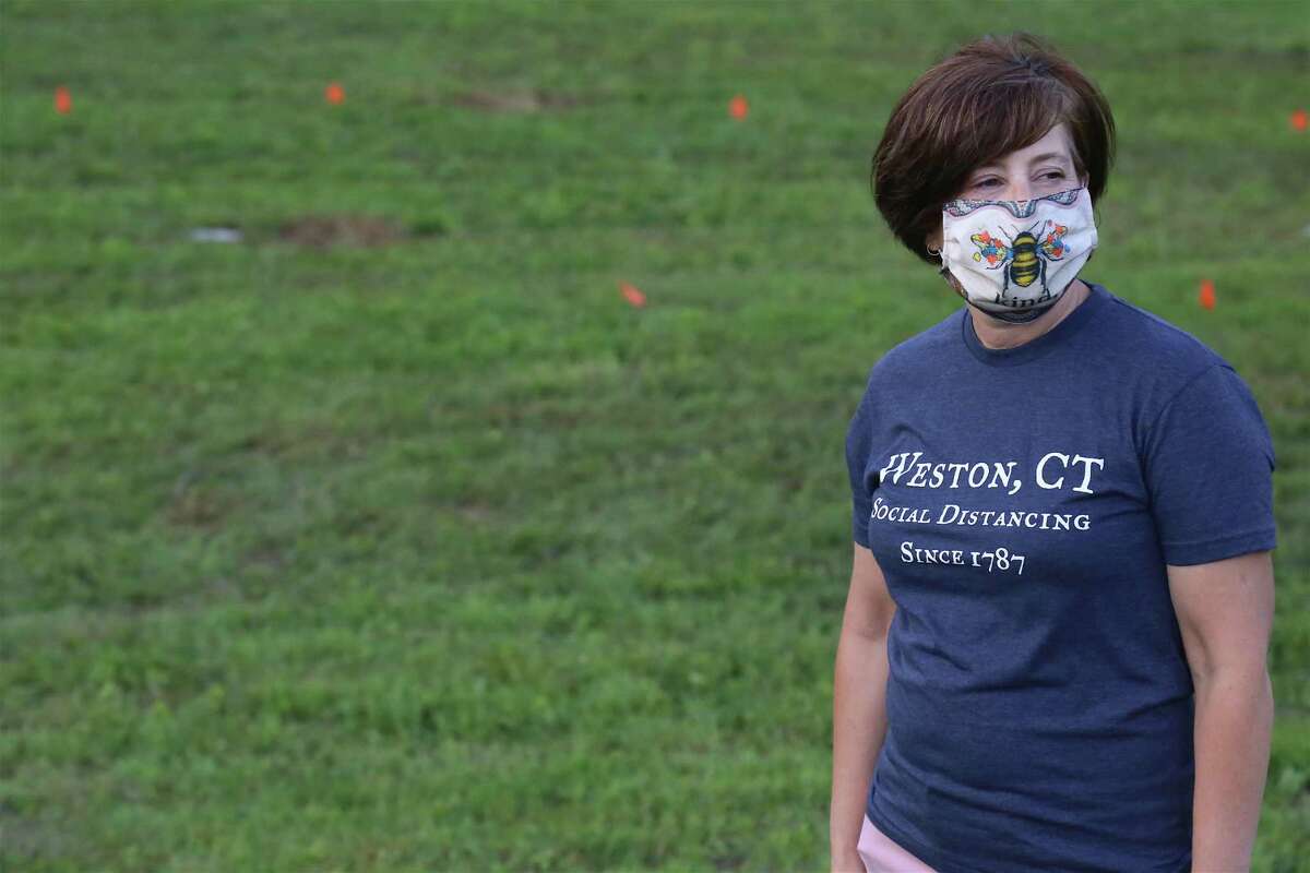 Volunteer Rose Cruz of Weston waits for cars to arrive at the Lachat Town Farm pop-up drive-in movie screening of "Caddyshack" on Sunday, July 19, 2020, in Weston, Conn. "Lachat Town Farm has become an epicenter of what Weston stands for - community and family," said resident Harry Falber. "It's people getting together and having a good time." Along with enjoying the film with his family, Nashawaty praised the chance to enjoy an old-fashioned drive-in. "I grew up with them as a kid," he said. "This is such a great thing for the community."