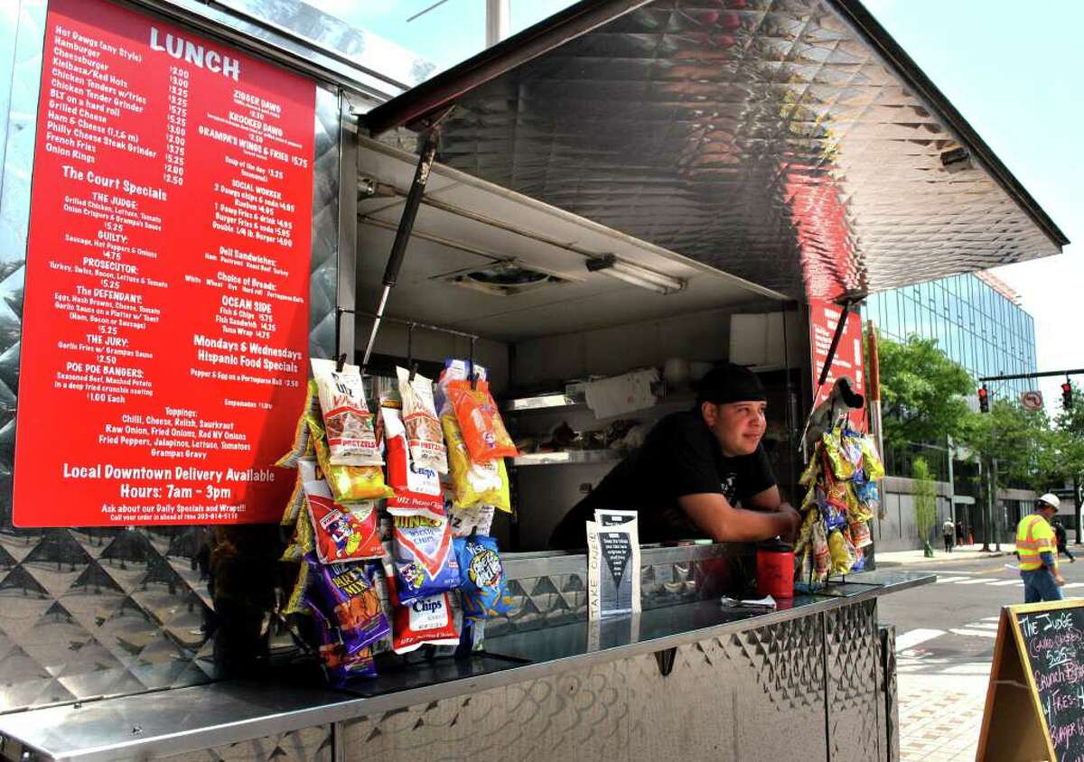 Joe Marzan tends the Snappy Dogs food cart recently outside the State Courthouse on the corner of Fairfield Avenue and Main Street in Bridgeport. Marzan runs the cart with his mother Janet Marzan.