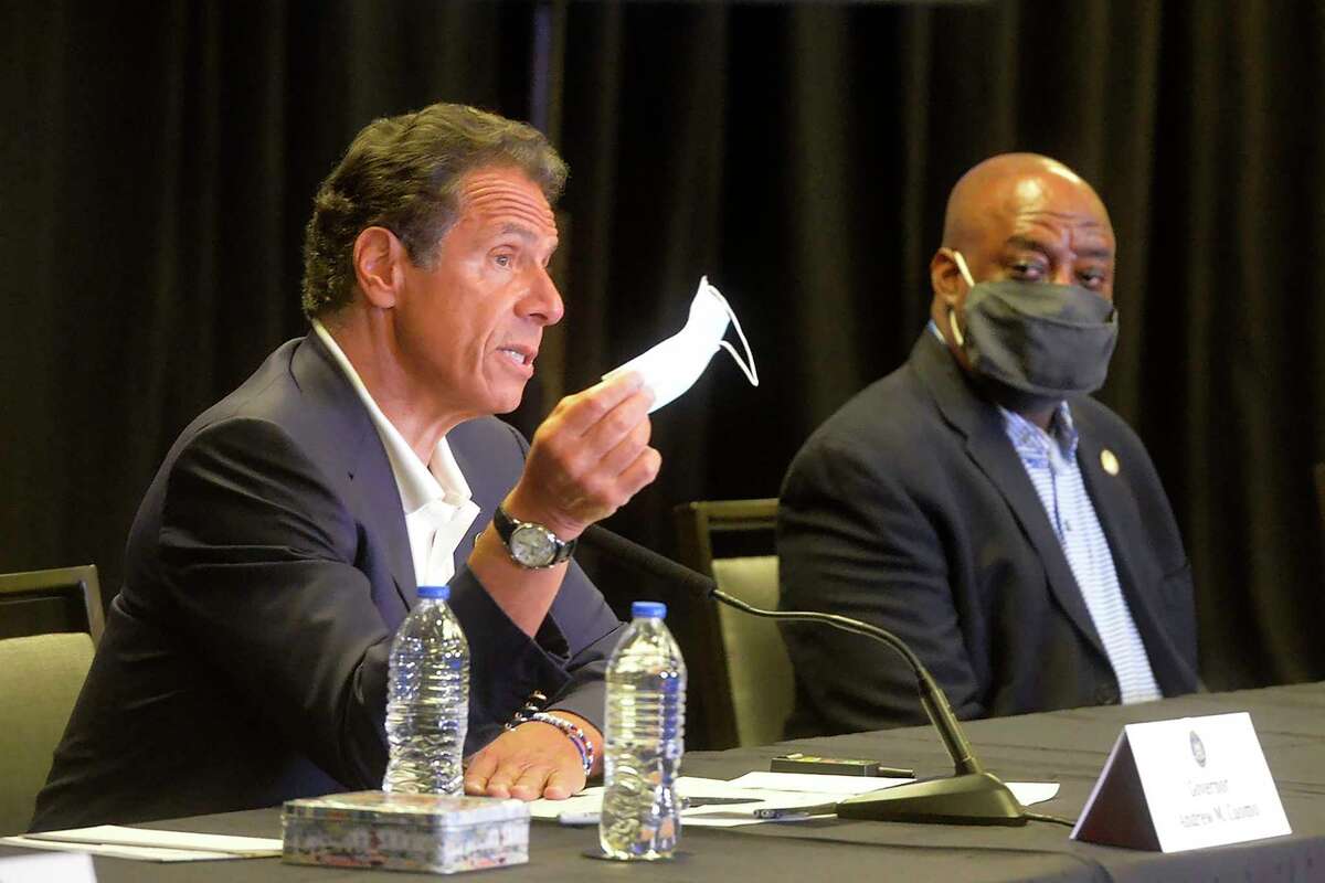 New York Gov. Andrew Cuomo waves a mask to make a point during a news conference at the Hyatt, in Savannah, Ga. on Monday, July 20, 2020. Listening in is Savannah Mayor Van Johnson.