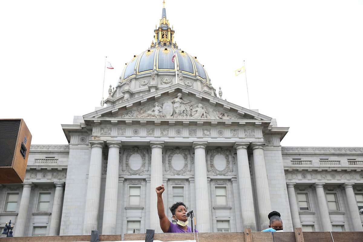 Theresa Rutherford, vice president of SEIU 1021 sings We Shall Overcome as she holds her first in the air during a Strike for Black Lives protest at City Hall on Monday, July 20, 2020 in San Francisco, Calif.