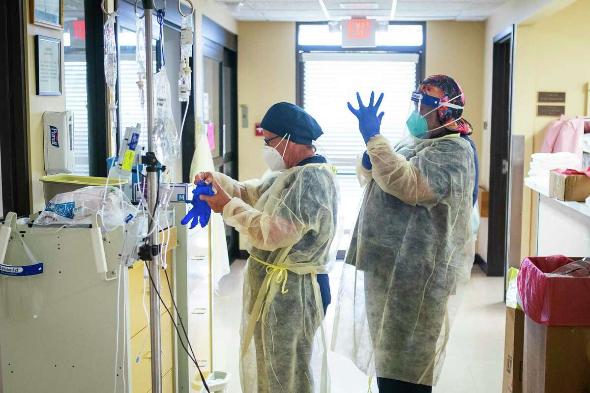 Nurses put on extra protective equipment while working in the hospital's four bed ICU, Monday, July 20, 2020, at El Campo Memorial Hospital in El Campo, TX. The small, rural hospital currently has three out of their four ICU beds filled with COVID-19 positive patients.