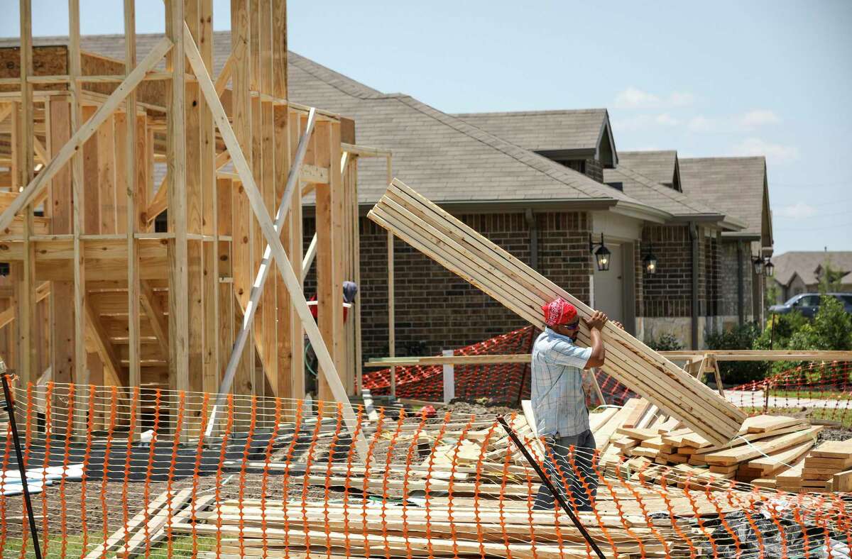 Men work to build a house in Lakeview Retreat, a D.R. Horton master-planned community, Tuesday, June 16, 2020, in Richmond.