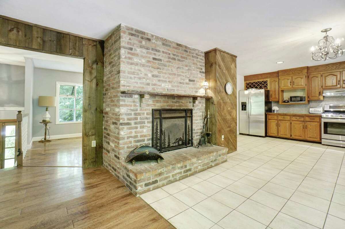 In the kitchen there is a fireplace, stainless appliances, ample cabinetry and a built-in wine rack above the refrigerator. The walls of the den and part of the kitchen are lined in barn board. Features in this sizable kitchen include ample cabinetry, stainless appliances, and there is room for a center island. In the eat-in section there are sliding doors to the deck. Relaxation is augmented not only by the deck but by the pergola that can be enhanced with crushed stones and fabric drapes to create a backyard of casual luxury. A brick platform is pre-wired for an outdoor hot tub.