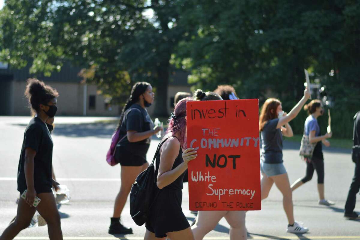 A protest that marched from North Haven High School to the town's police department called for change in the school system regarding racism and defunding the police to invest in community resources.